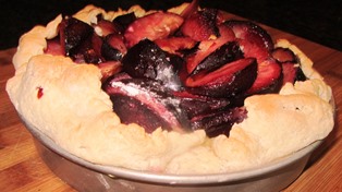 Pluots or plums are first drizzled in lemon juice and dusted with flour, then placed into the tart with bits of butter