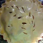 Pie with egg wash applied and vents cut in is ready to bake